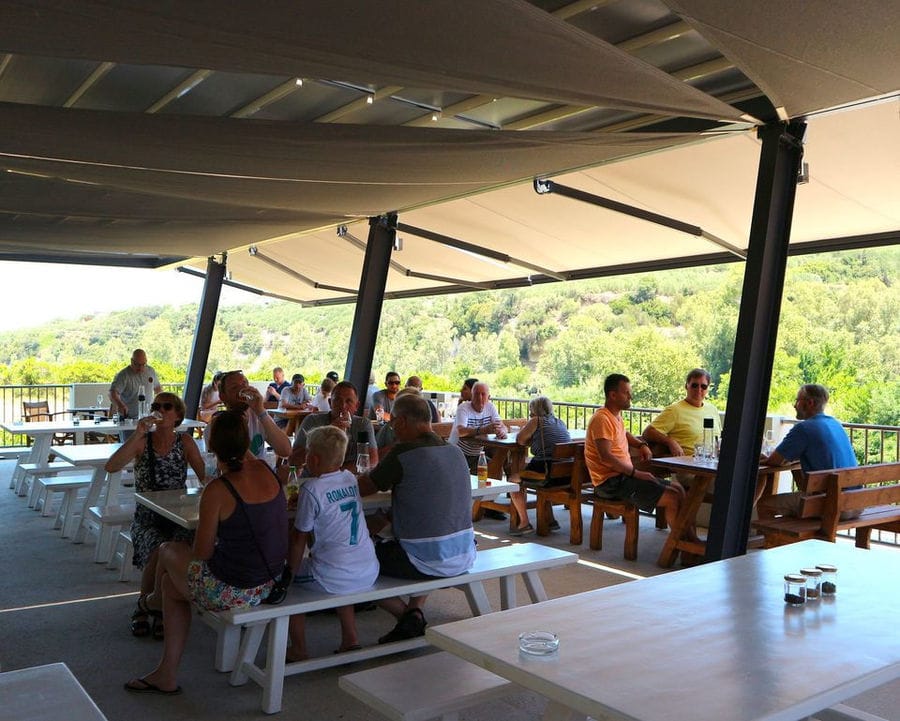 tourists sitting around the tables and tasting beer at Cretan Brewery restaurant